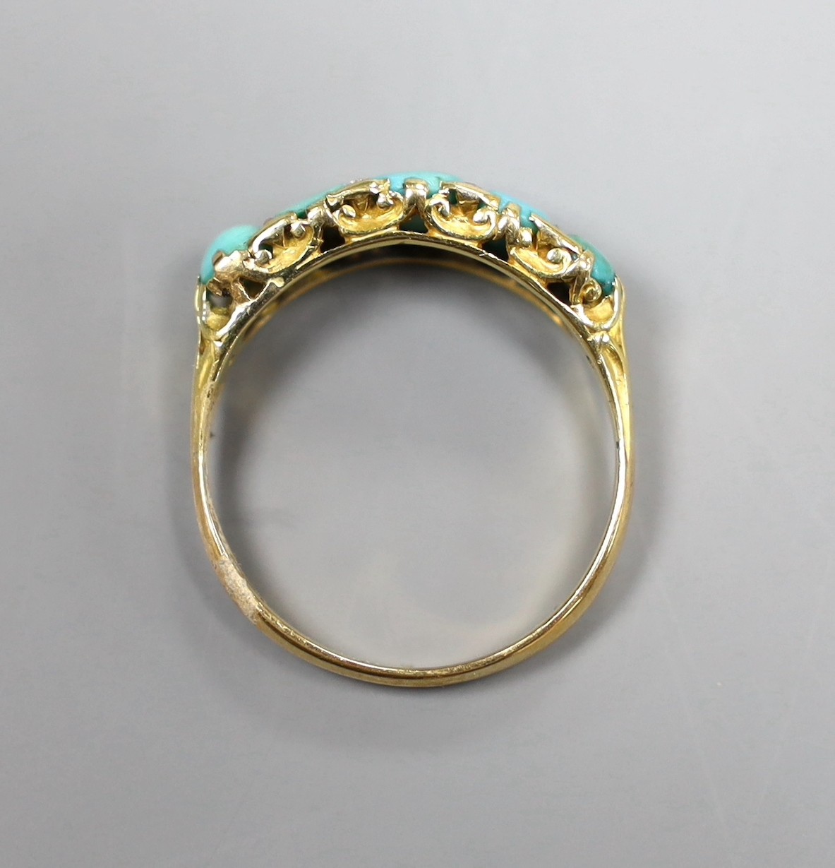 An 18ct gold turquoise set five stone half hoop ring with diamond chip intersections, size R, gross 3.5 grams